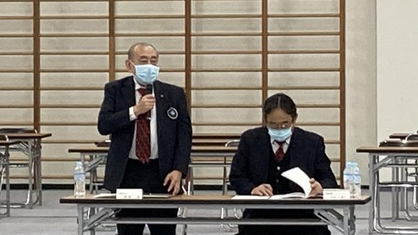 理事会開会にあたり挨拶を述べる岡﨑温会長代行