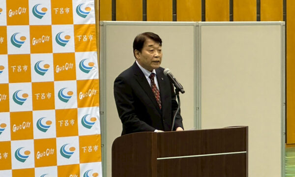 加藤勝信会長の歓迎のことばを川﨑雅雄副会長が代読