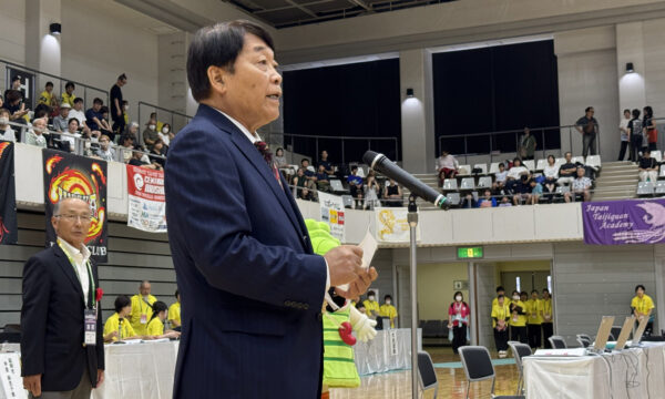 加藤勝信会長のご挨拶を川﨑雅雄副会長が代読