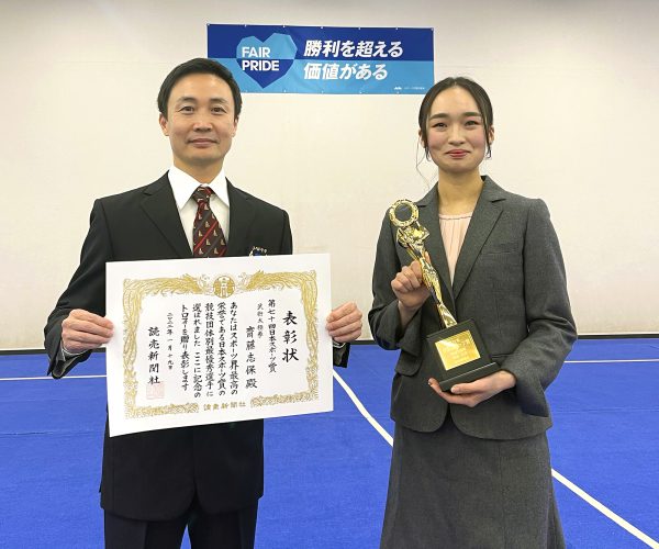 トロフィーを手に笑顔をみせる齋藤志保選手と孔祥東 理事・選手強化委員会委員長 ※撮影時のみマスクを外しています